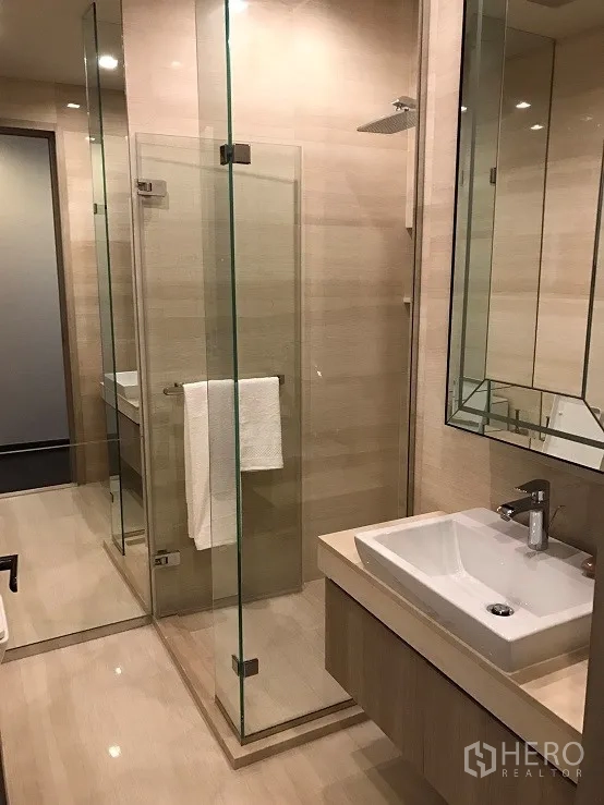 คอนโด ให้เช่าหรือขายในWatthana, Bangkok - ห้องน้ำสมัยใหม่ มีตู้ชาวเวอร์กระจก ฝักบัวเรนชาวเวอร์ กระเบื้องโทนอ่อน และอ่างล้างหน้า