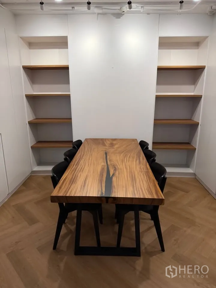 Condominium for rent in Watthana, Bangkok - Dining room with live-edge wooden table, black chairs, and shelves.