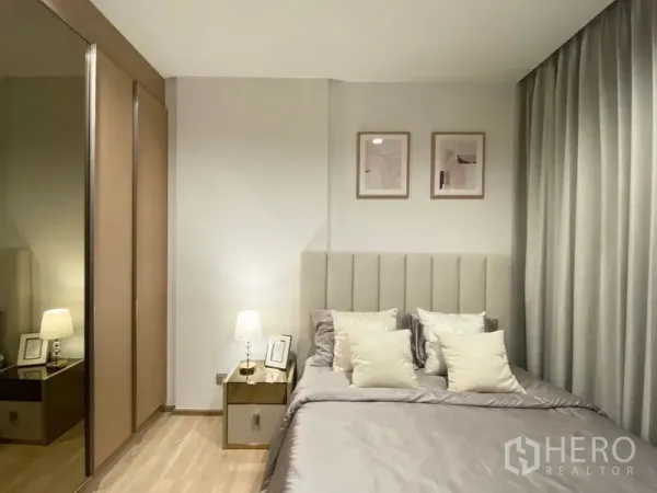 คอนโด ให้เช่าหรือขายในWatthana, Bangkok - ห้องนอนมาสเตอร์ เตียงหัวเตียงบุผ้า โต๊ะข้างพร้อมโคมไฟ ตู้เสื้อผ้าบานกระจก และชุดเครื่องนอนโทนเทา