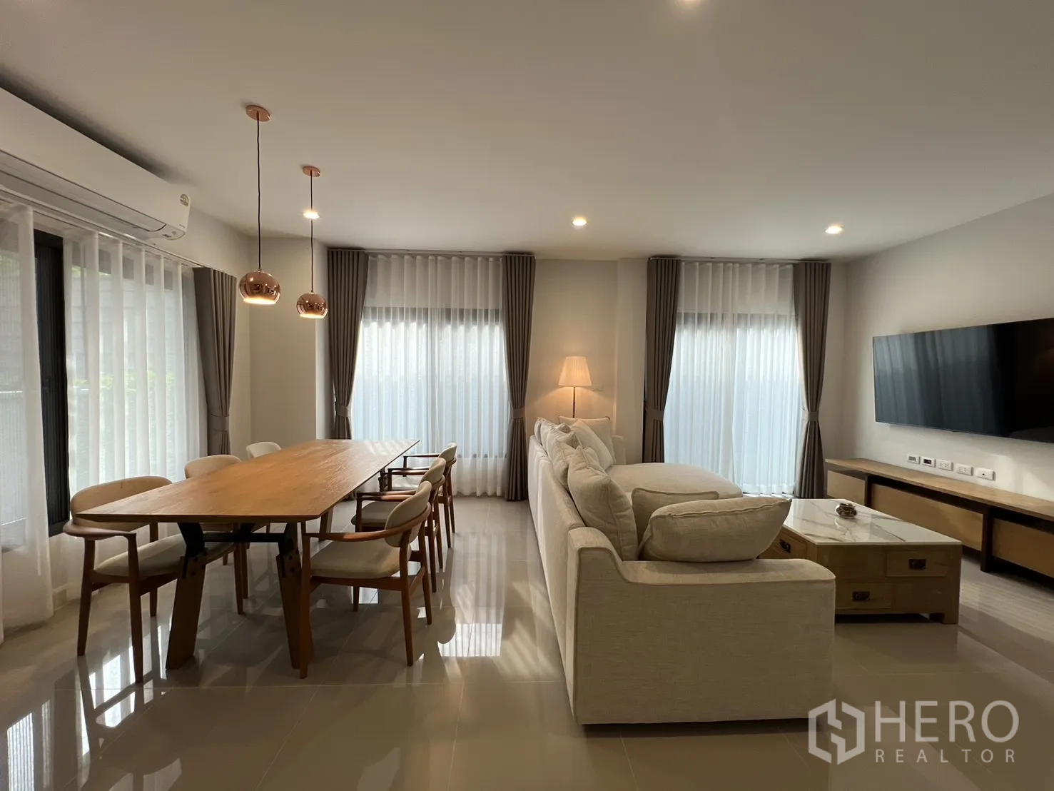 Detached House for rent in Prawet, Bangkok - Dining and living space with pendant lights and full-height windows.