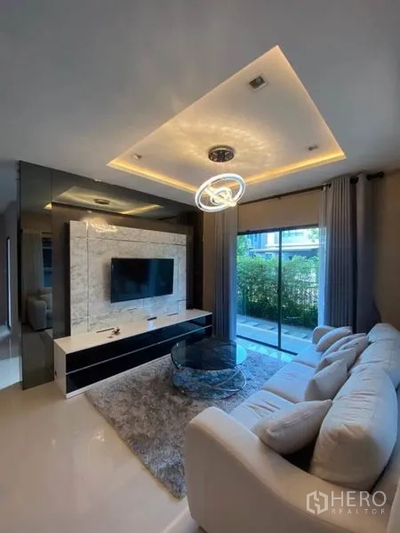 บ้าน ให้เช่าหรือขายในSaphan Sung, Bangkok - ผนังทีวีลายหินอ่อนตรงข้ามโซฟา มองเห็นสวนด้านนอก