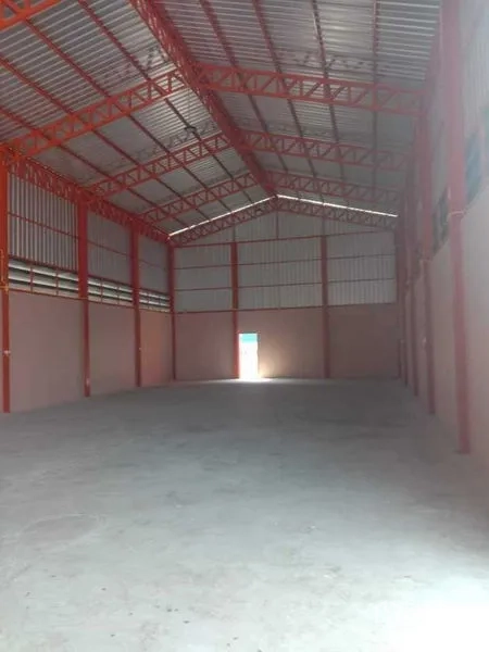 Warehouse for rent in Pathum Thani - Spacious clear-span warehouse interior with high gabled roof and concrete floor.