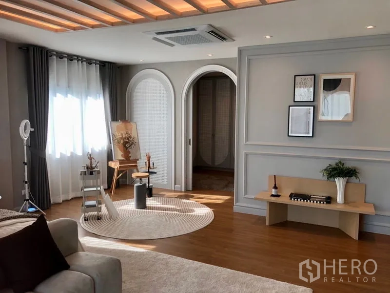 Detached House for sale - Upper-floor multipurpose area with arched doorways, tray ceiling lighting, wood floors and decor bench.