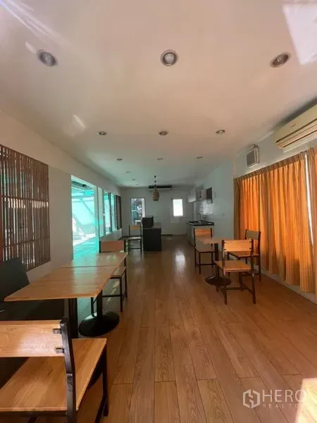 พื้นที่ขายปลีก ให้เช่าในWatthana, Bangkok - ห้องค้าปลีกยาวปูพื้นไม้ มีโต๊ะ เก้าอี้ มุมแพนทรี่ และแอร์ผนัง