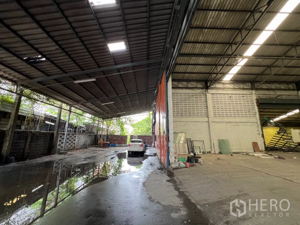 Warehouse for rent in Khlong Sam Wa, Bangkok - Semi-open covered forecourt for loading and parking beside the warehouse entrance.