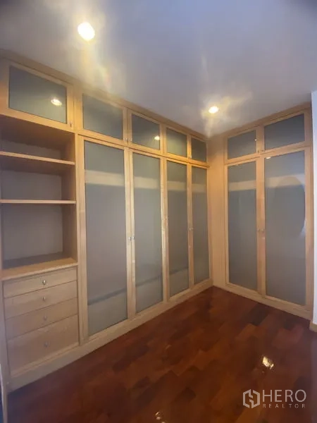 Condominium for rent - Room with built-in wardrobes featuring frosted glass doors, shelving and polished wood floors.