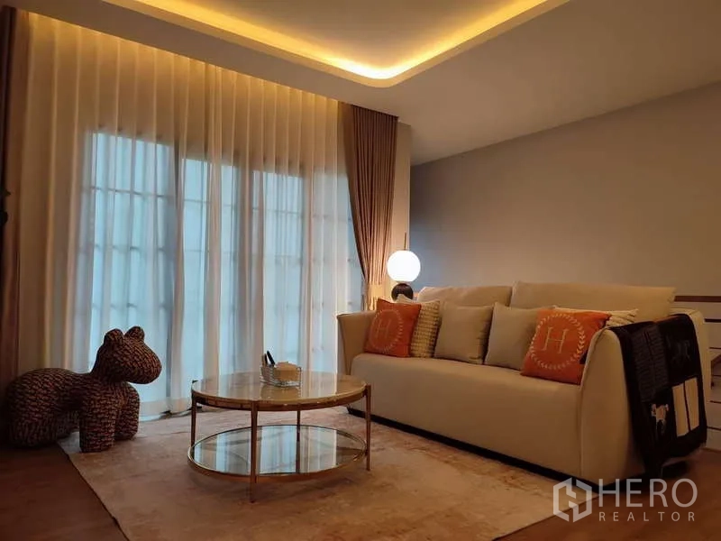 Detached House for rent in Bang Phli, Samut Prakan - Upstairs sitting area with sofa, round glass coffee table and ambient lighting.