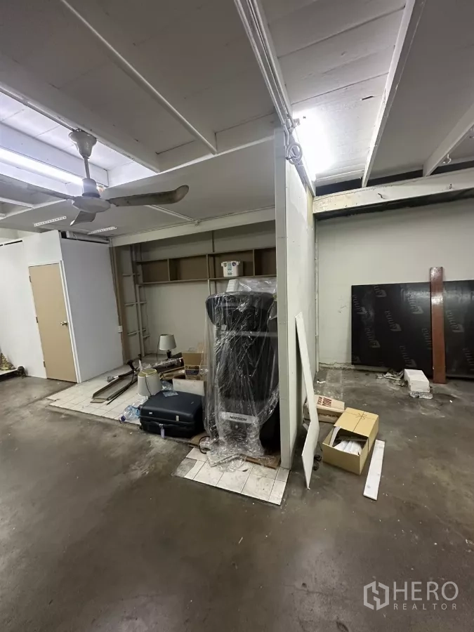 零售空间 出租在Watthana, Bangkok - 室内水泥地面与白色天花板、吊扇，待装修的储物区