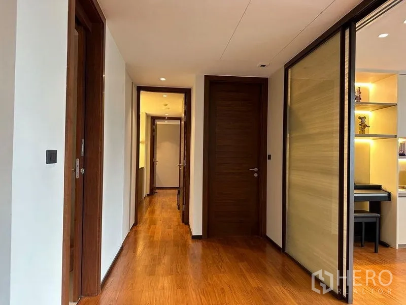 คอนโด ขายในWatthana, Bangkok - โถงทางเดินพื้นไม้ ประตูไม้ และชั้นบิวท์อินพร้อมไฟส่องสว่าง