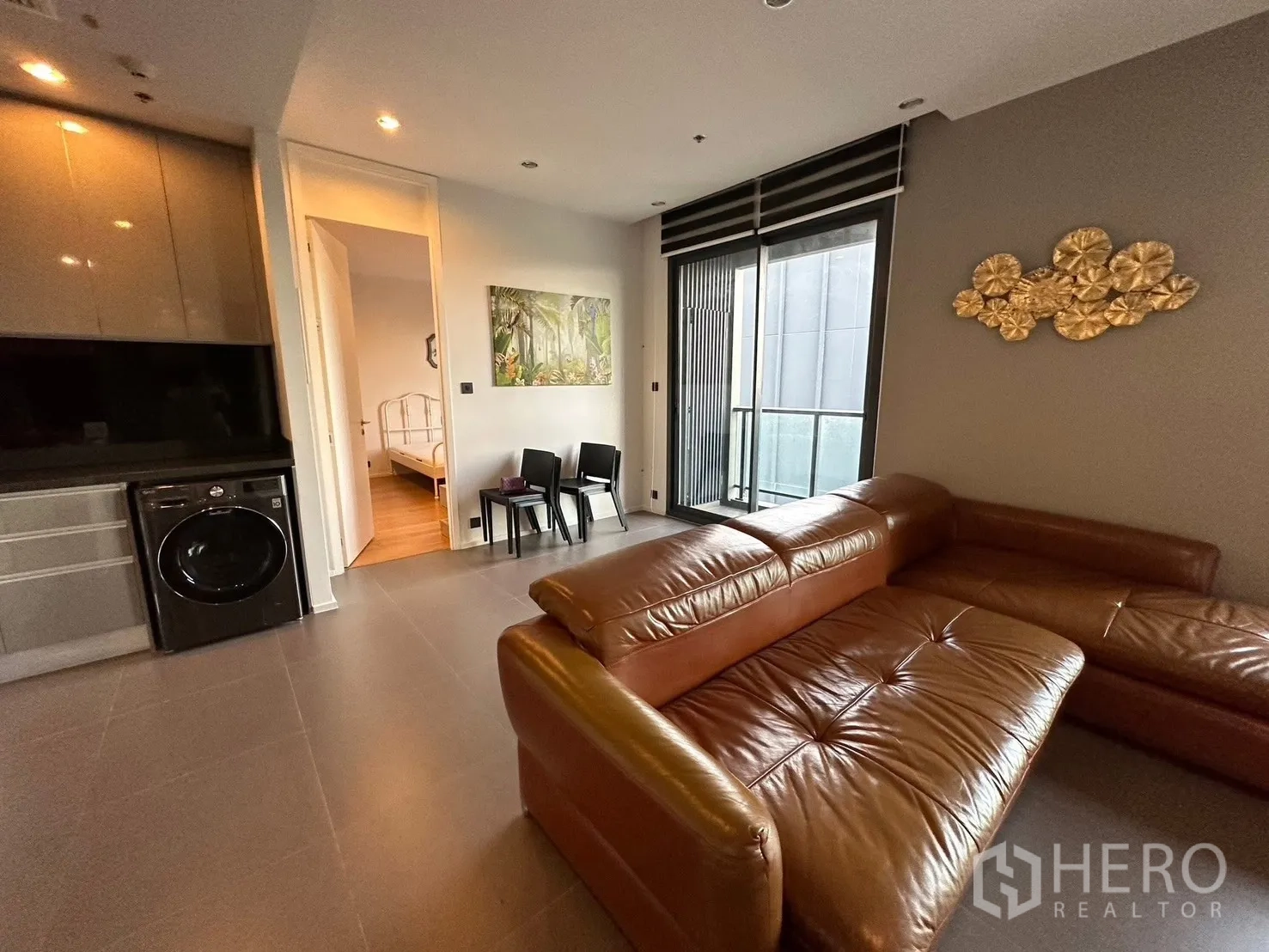คอนโด for rent or sale in Chatuchak, Bangkok - โซฟารูปตัวแอลใกล้ระเบียง มองเห็นวิวเมือง