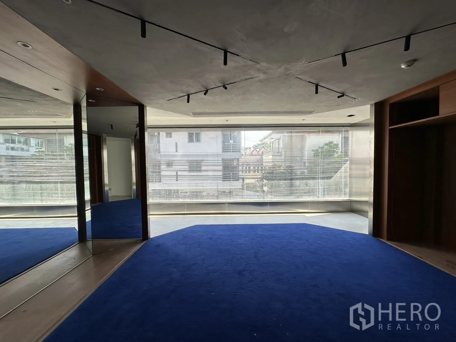 Retail Space for rent in Watthana, Bangkok - Upper level space with a wide window, blue carpet, and ceiling track lights.