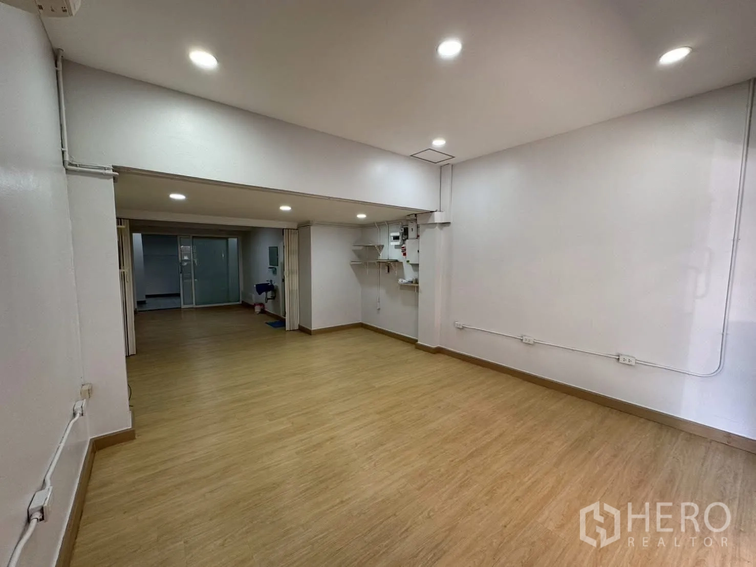 Home Office for rent in Sathon, Bangkok - Well-lit open room with shelves, AC units, and ample outlets.