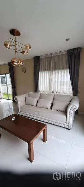 บ้าน ให้เช่าในLat Krabang, Bangkok - ห้องนั่งเล่นสว่างด้วยหน้าต่างบานใหญ่ โซฟาหนานุ่มและโต๊ะกาแฟ