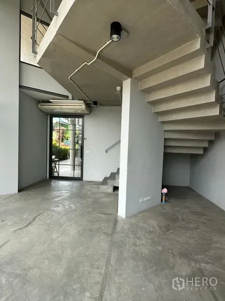 Home Office for rent or sale in Prawet, Bangkok - Double-height lobby with exposed concrete staircase and polished floors.