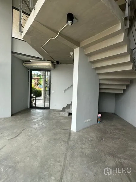 Home Office for rent or sale in Prawet, Bangkok - Double-height lobby with exposed concrete staircase and polished floors.