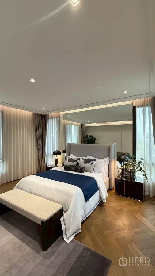 Detached House for sale in Saphan Sung, Bangkok - Guest bedroom with large windows, mirrored wall and soft drapery.