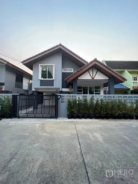 บ้าน ให้เช่าในKhlong Toei, Bangkok - ด้านหน้าบ้านเดี่ยวโทนสีเทา หลังคาจั่ว รั้วประตู และแนวไม้กระถางหน้าบ้าน