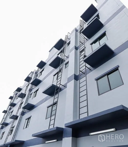 Shophouse for sale in Lam Luk Ka, Pathum Thani - Modern multi-storey commercial building exterior with windows and service ladders.