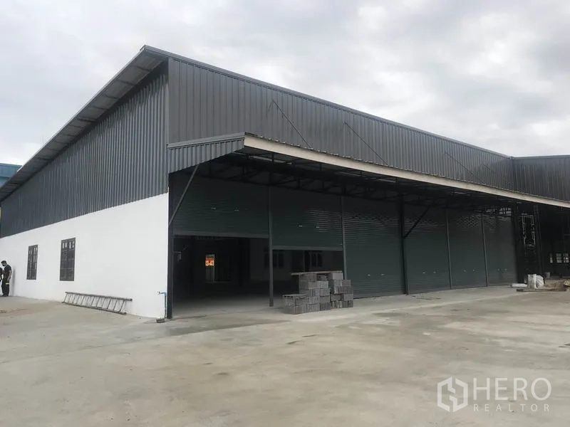 Warehouse for rent in Pathum Thani - Corner exterior of the warehouse with covered loading dock and ample parking apron.