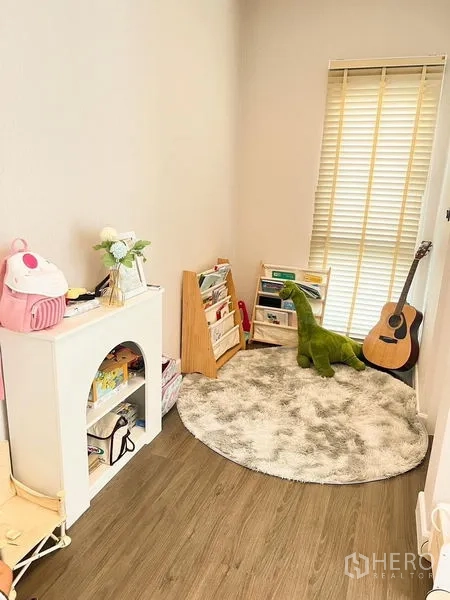 Detached House for sale in Bang Kapi, Bangkok - Compact study or kids’ playroom with shelves, a round rug and window blinds.