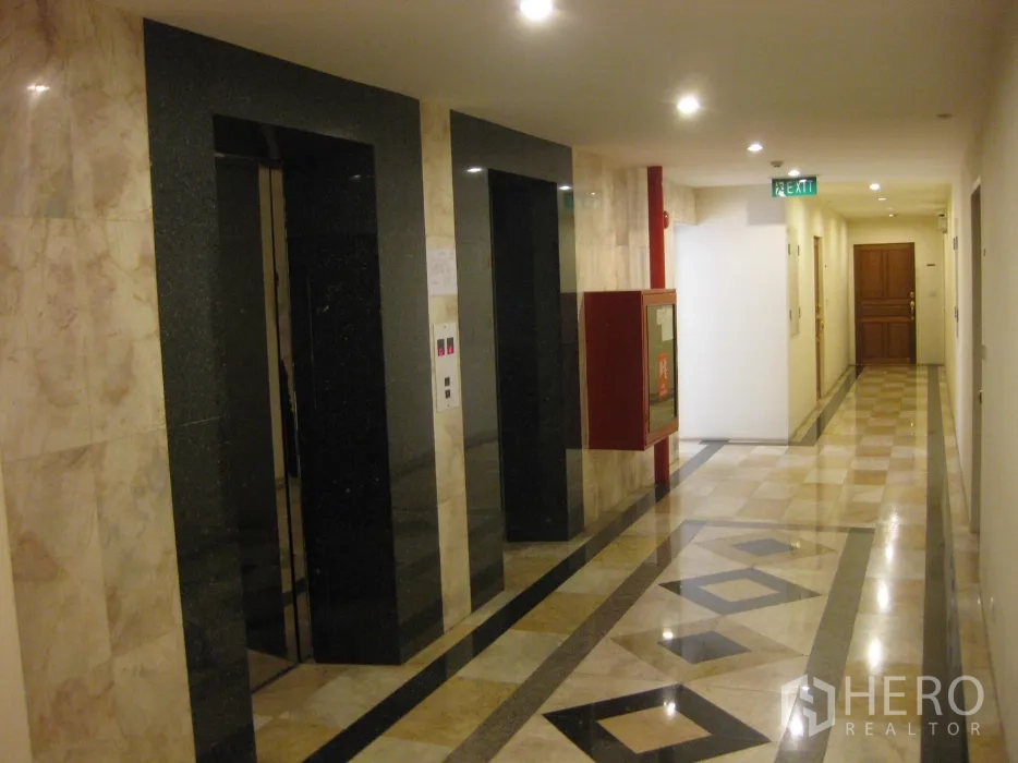 Condominium for rent or sale in Watthana, Bangkok - Condo corridor with two elevators and polished marble floors.