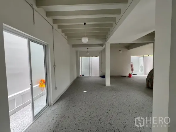 สำนักงานที่บ้าน ให้เช่าในHuai Khwang, Bangkok - ห้องยาวแบบโอเพ่นพร้อมประตูกระจกบานเลื่อนไปยังคอร์ทยาร์ด ผนังขาว คานเพดาน