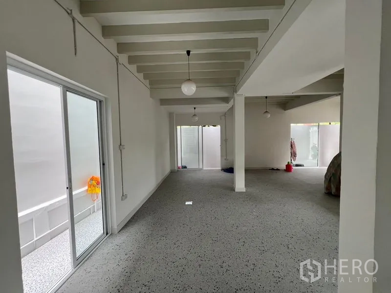 สำนักงานที่บ้าน ให้เช่าในHuai Khwang, Bangkok - ห้องยาวแบบโอเพ่นพร้อมประตูกระจกบานเลื่อนไปยังคอร์ทยาร์ด ผนังขาว คานเพดาน