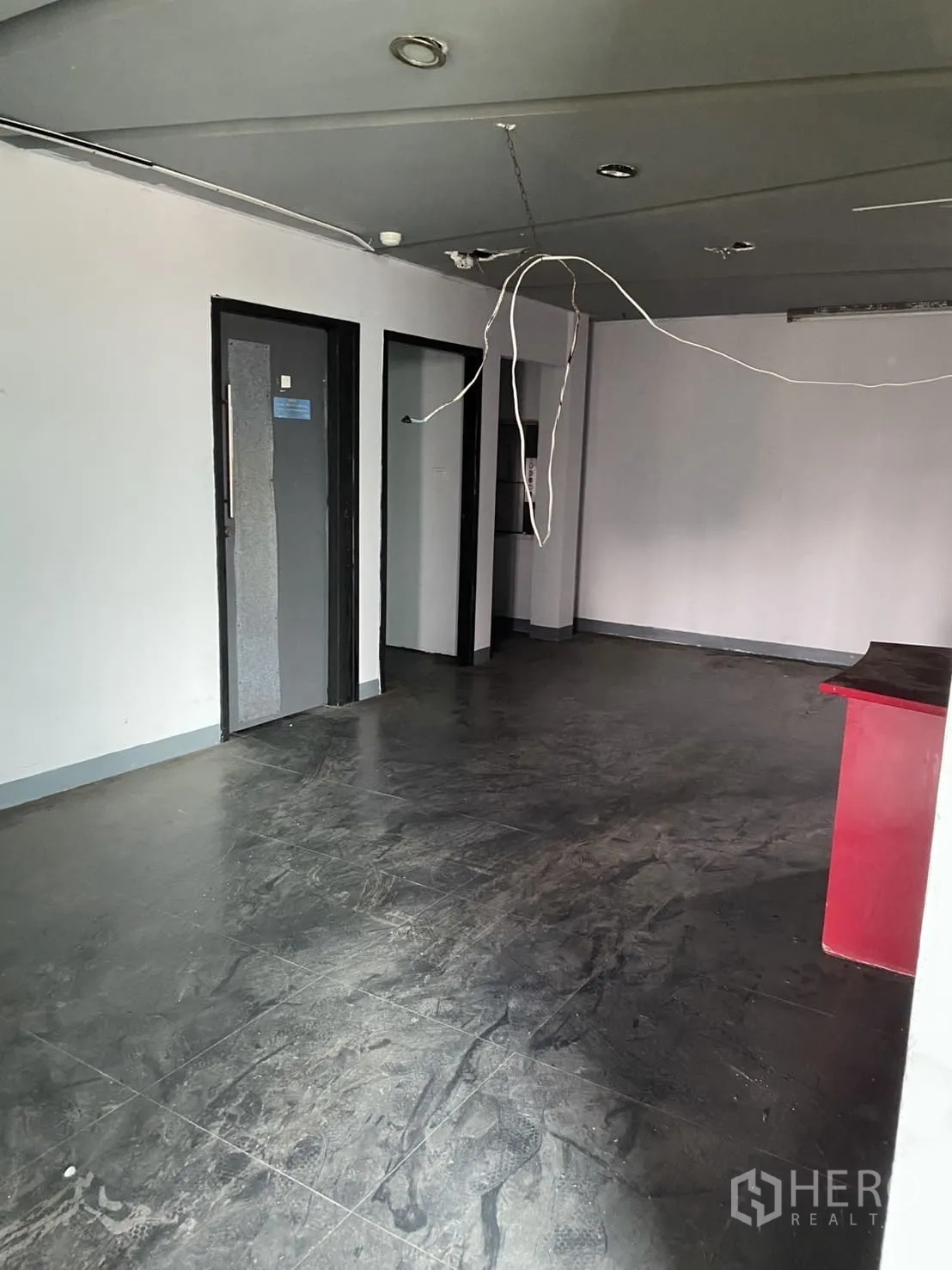 展厅 出租在Lat Phrao, Bangkok - 开放式房间，深色地砖与吊顶灯具，适合办公室或展厅。