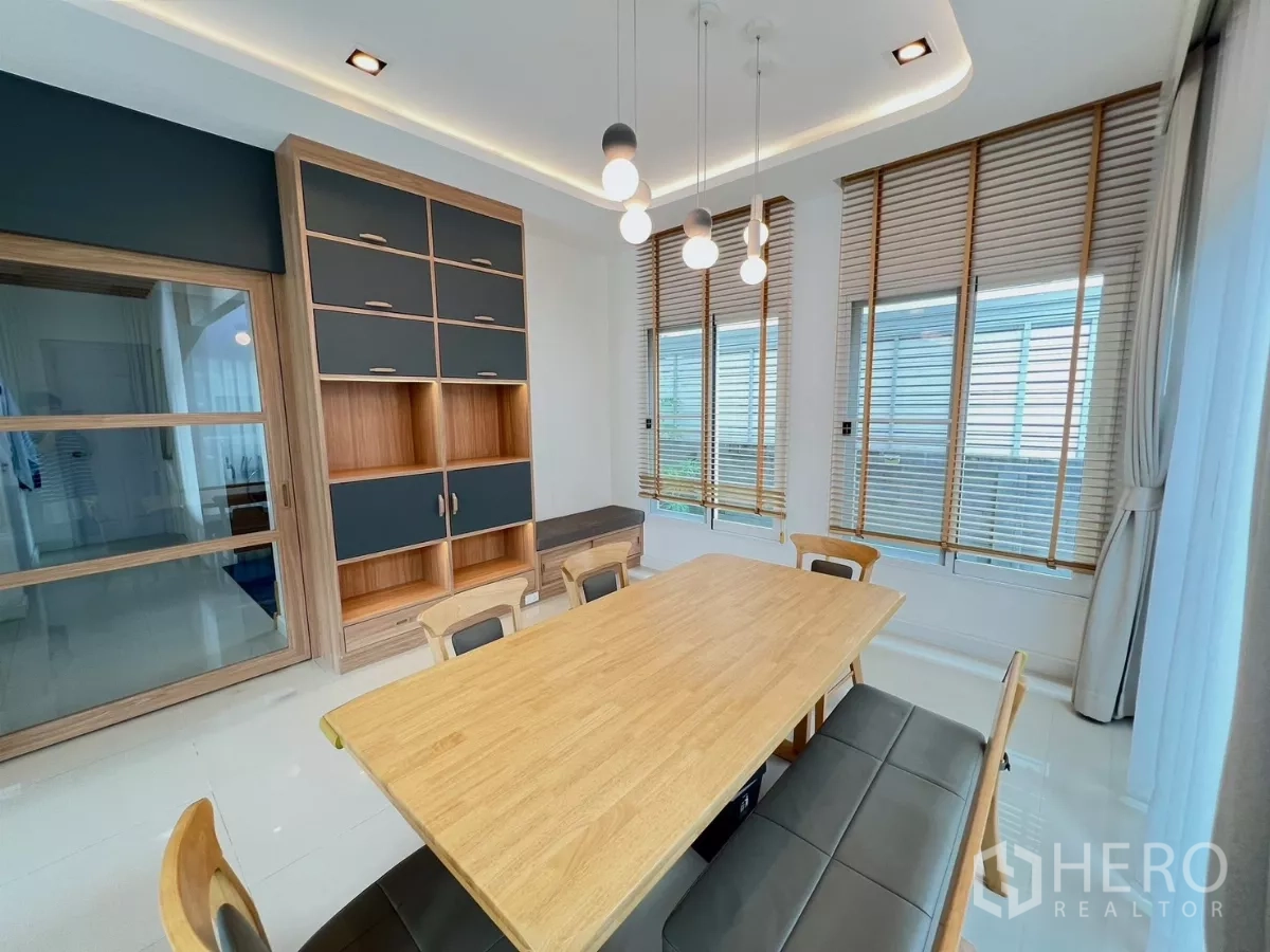 独立式住宅 出租或出售在Khlong Luang, Pathum Thani - 餐区配木质餐桌、吊灯与转角百叶窗
