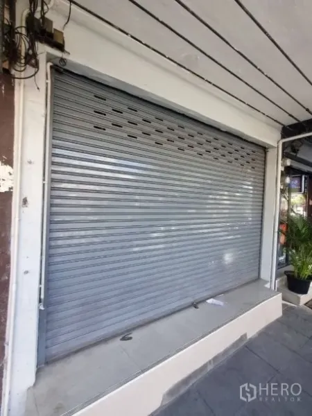 อาคารพาณิชย์ ให้เช่าในKhlong Toei, Bangkok - ด้านหน้าร้านพร้อมประตูเหล็กม้วนและชานทางเท้าปูกระเบื้อง