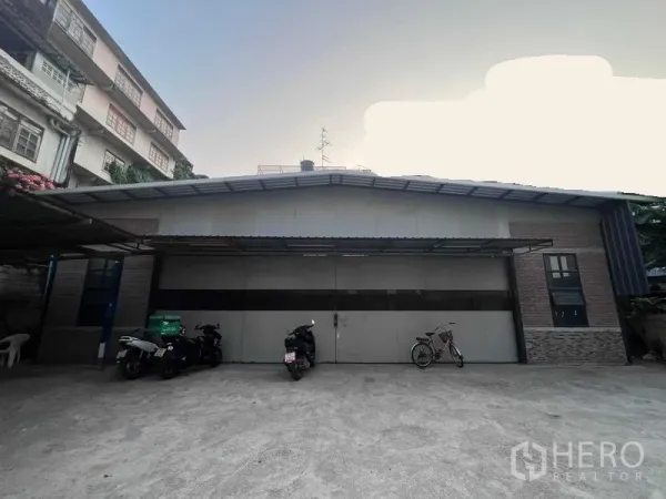 คลังสินค้า ให้เช่าในBang Kapi, Bangkok - ด้านหน้าโกดังพร้อมประตูบานใหญ่และลานจอดรถ