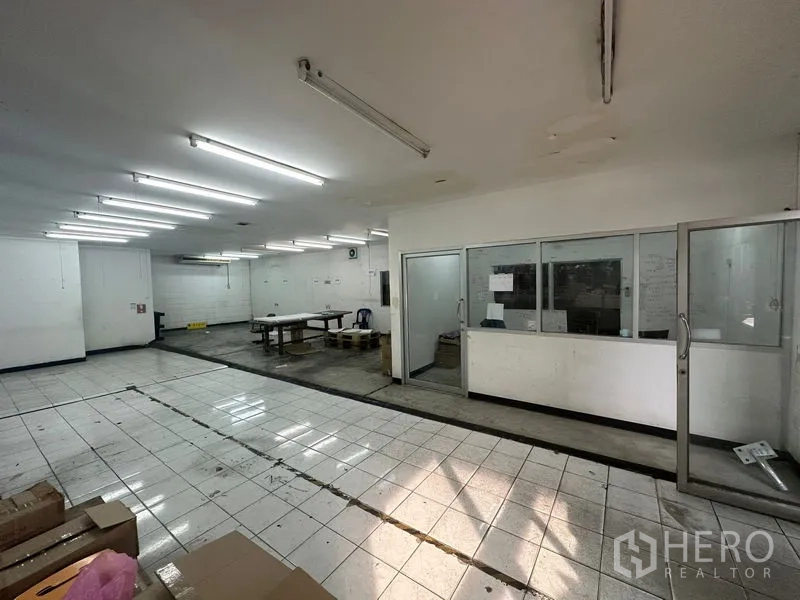 คลังสินค้า ให้เช่าในKhlong Toei, Bangkok - พื้นที่ทำงานปูกระเบื้องสว่าง พร้อมไฟฟลูออเรสเซนต์ และออฟฟิศกั้นกระจกภายในโกดัง.
