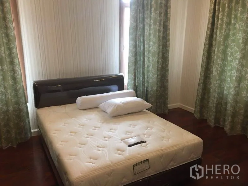 Detached House for rent in Bang Phli, Samut Prakan - Sunny bedroom with double bed, wood floors, and green floral curtains.