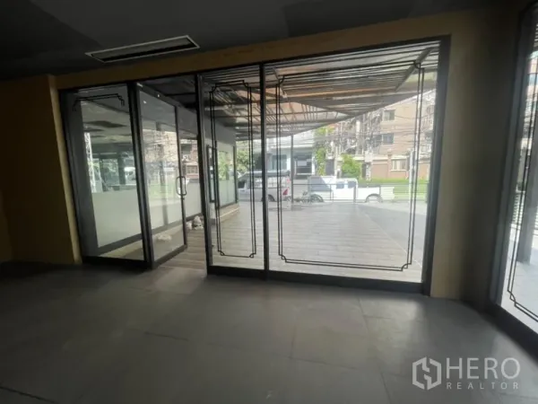 พื้นที่ขายปลีก ให้เช่าในKhlong Toei, Bangkok - มุมมองจากภายในสู่ประตูกระจก ทางเดินและพื้นที่ชานด้านหน้าแบบมีหลังคา