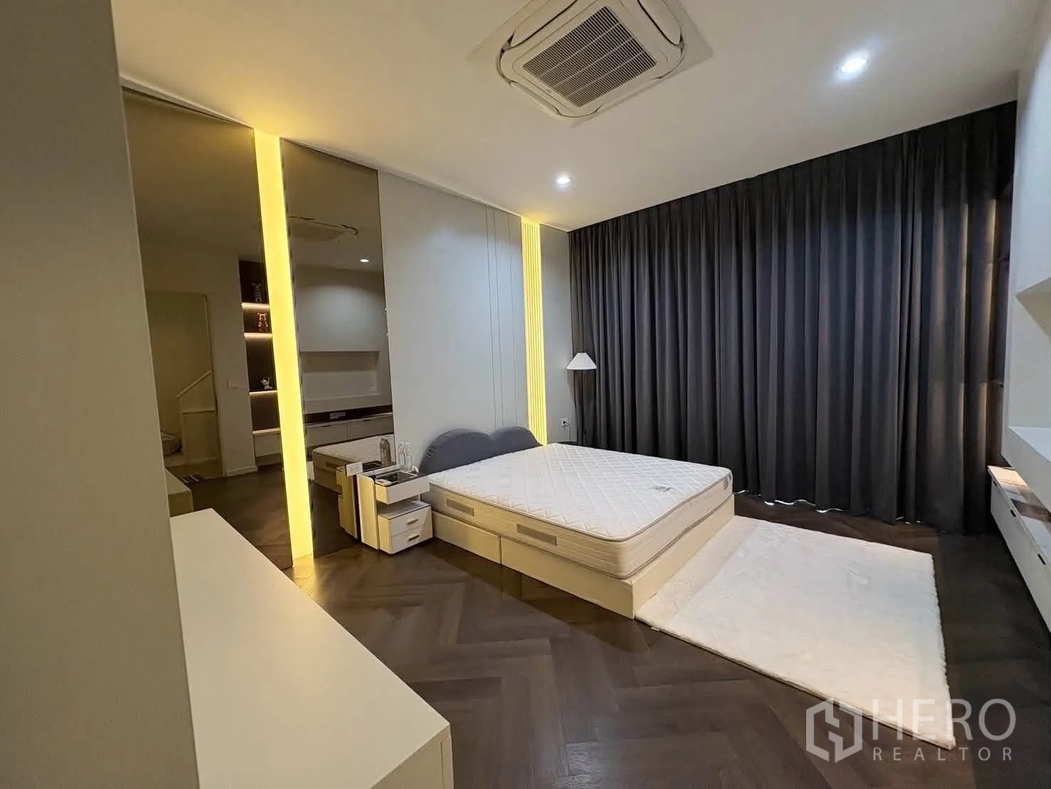 Detached House for rent in Saphan Sung, Bangkok - Spacious bedroom with large bed, cassette air-conditioning, dark drapes, and herringbone floors.