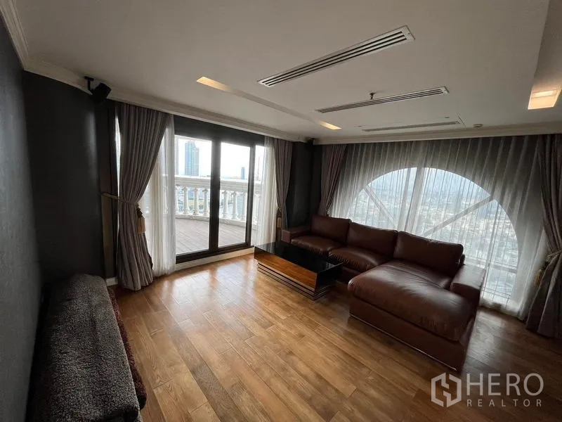 公寓 出售在Bang Rak, Bangkok - 舒适起居角，皮质转角沙发、木地板并通向露台。