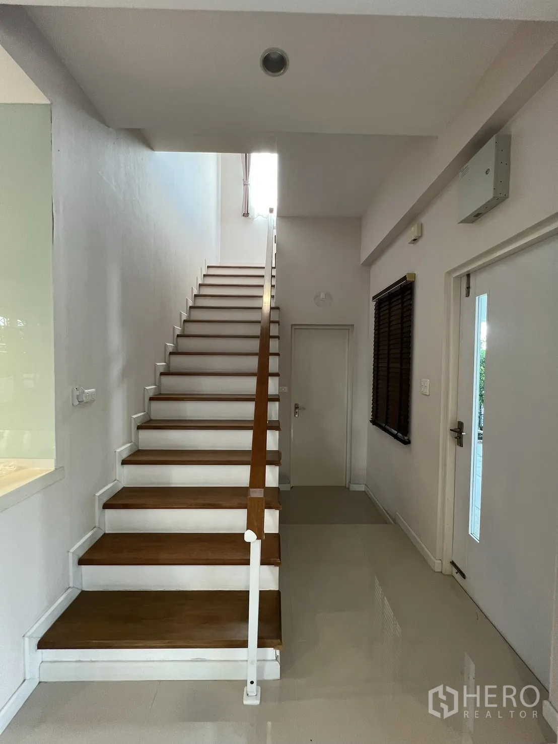 บ้านเดี่ยว for rent in Bang Kapi, Bangkok - โถงทางเข้าและบันไดไม้เพดานสูงกับพื้นกระเบื้องเงา.