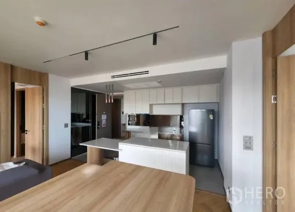 公寓 出租或出售在Phaya Thai, Bangkok - 开放式厨房，配备中岛、白色橱柜、吊灯与不锈钢冰箱的现代曼谷公寓。