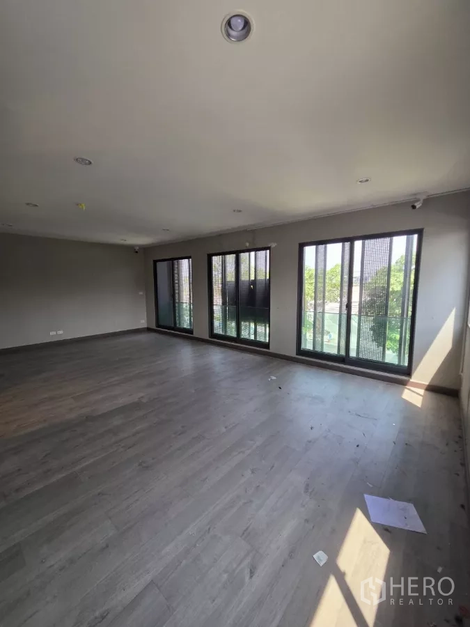 Home Office for rent in Pak Kret, Nonthaburi - Spacious open-plan office level with wood flooring and wall-to-wall windows bringing natural light.