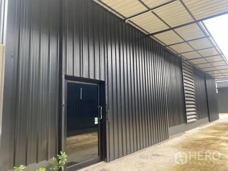 คลังสินค้า ให้เช่าในLat Phrao, Bangkok - ประตูทางเข้าด้านข้างโกดังใต้กันสาดป้องกันฝน.