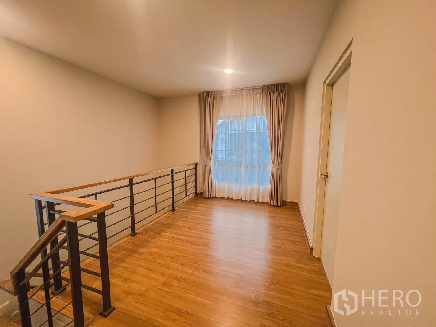 独栋房屋 for rent in Bang Phli, Samut Prakan - 二层过厅配金属木扶手与木纹地板，设窗帘大窗。
