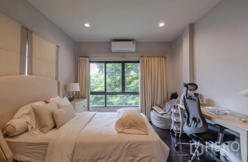 Detached House for rent or sale in Bang Kapi, Bangkok - Bedroom with wide window and garden view.