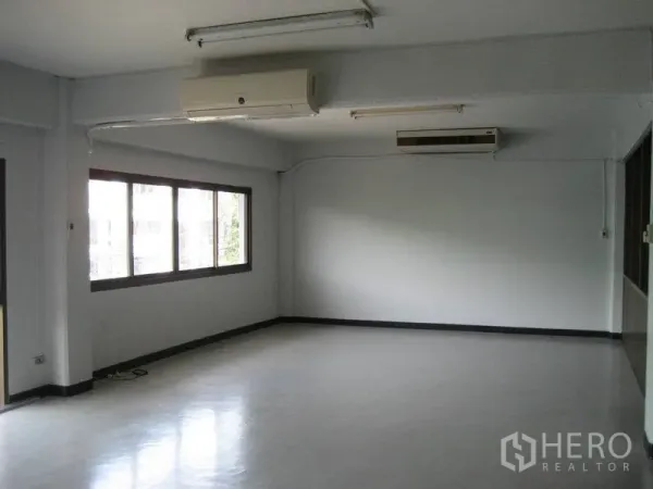 Factory for rent in Bang Sao Thong, Samut Prakan - Bright office room with large windows, glossy floor, and fluorescent ceiling lights.