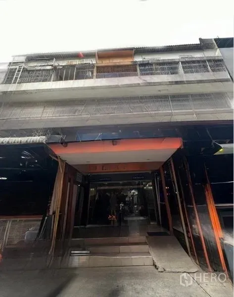 店屋 出租或出售在Watthana, Bangkok - 店屋街景外立面，呈内凹式入口与上部金属栏杆。