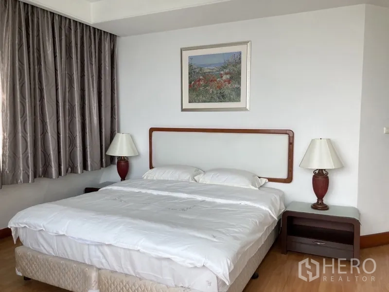 Condominium for rent in Yan Nawa, Bangkok - Master bedroom with king bed, bedside lamps and large window.