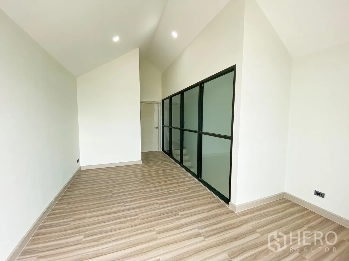 Home Office for rent or sale in Phra Khanong, Bangkok - Long gable-ceiling room with glass partition along the staircase.