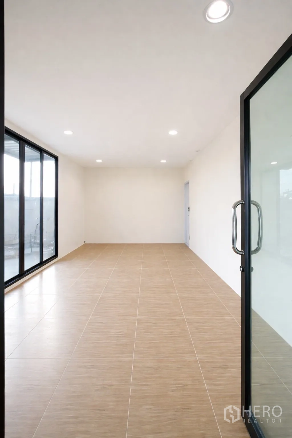 仓库 for rent in Prawet, Bangkok - 办公室内部，瓷砖地面、嵌入式照明和玻璃门。