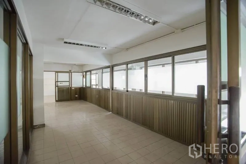 店屋 出租在Wang Thonglang, Bangkok - 长走廊，整面窗与半高木饰墙，配荧光灯照明。