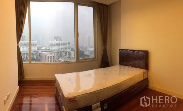 คอนโด ให้เช่าในWatthana, Bangkok - ห้องนอนพื้นไม้พร้อมเตียงเดี่ยวและหน้าต่างกว้างมองเห็นวิวกรุงเทพฯ