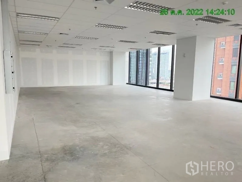 สำนักงาน ให้เช่าในRatchathewi, Bangkok - พื้นสำนักงานกว้างแบบยังไม่ตกแต่ง กระจกมุมบานใหญ่ ผนังสีขาว และไฟแบบกริด